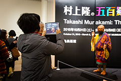 A visitor to the exhibition photographing the "Murakami Arhat Robot."