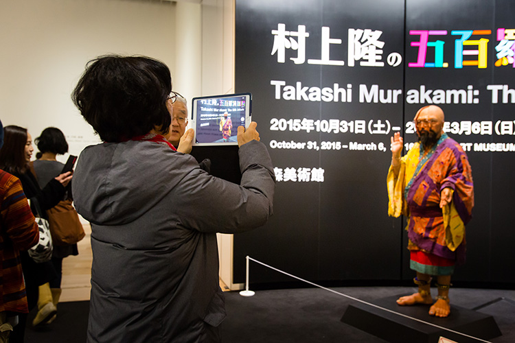 「村上羅漢ロボ」を撮影する来場者／A visitor to the exhibition photographing the "Murakami Arhat Robot."